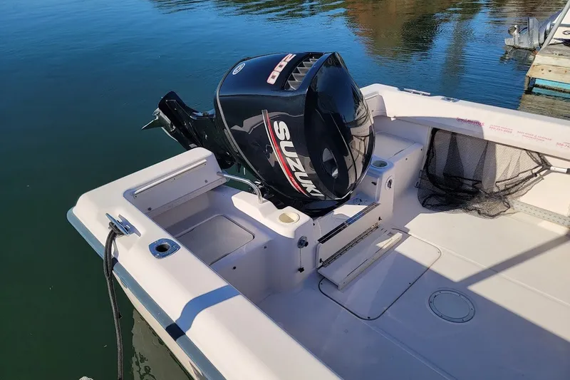 Slide: The Image of 1999 Grady-White Adventure 208 boat with Suzuki outboard motor on calm water. - 2