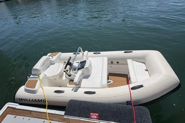 Slide: The Image of 2021 Williams Jet Tenders 325 Turbo Jet boat docked on calm water. - 1