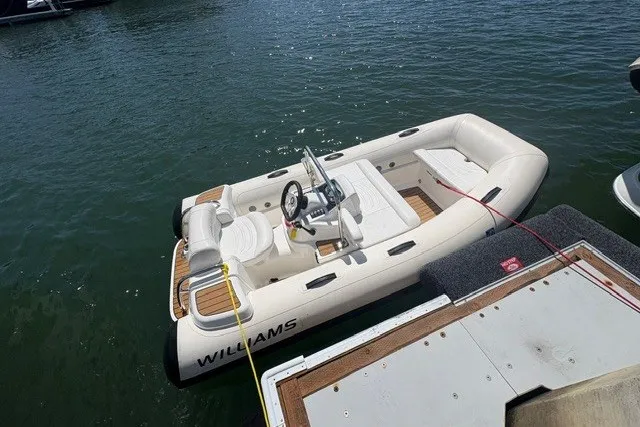 Slide: The Image of 2021 Williams Jet Tenders 325 Turbo Jet boat docked on calm water. - 4