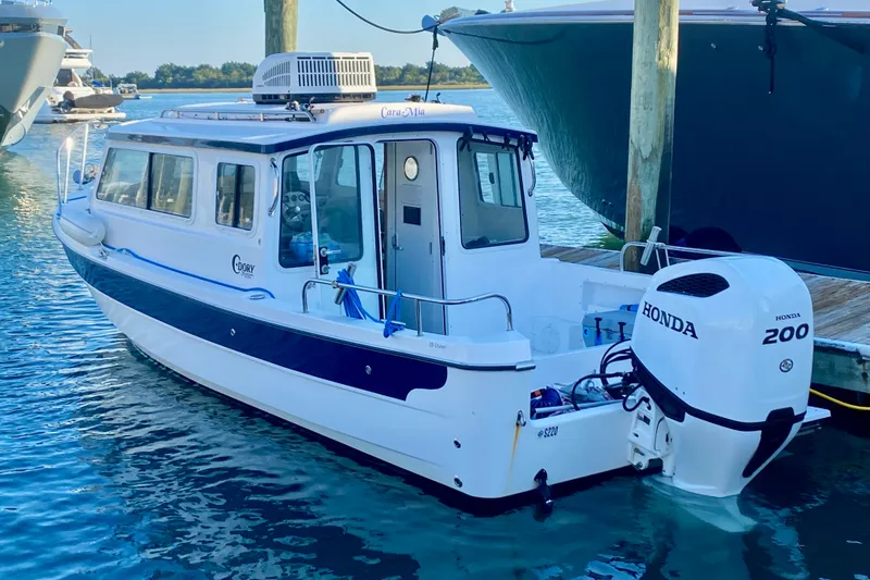 The Image of C-Dory 25' Cruiser 2021 boat with Honda 200 engine docked in marina. - 2