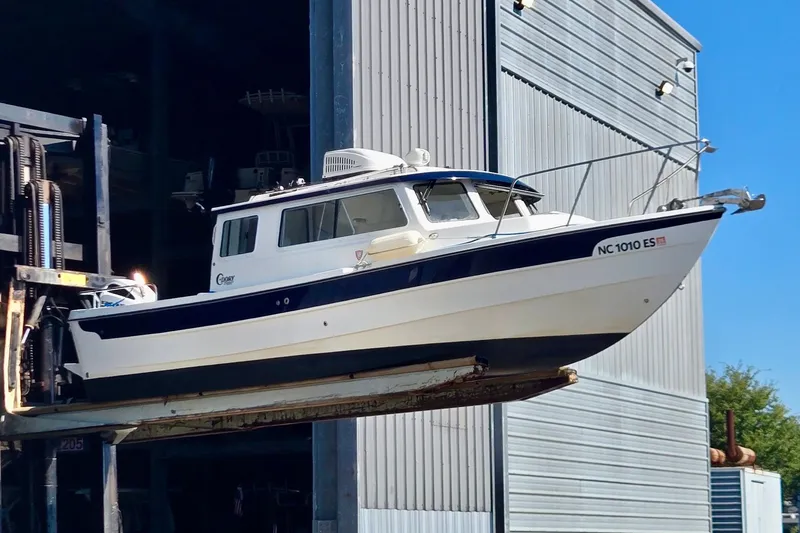 Slide: The Image of 2021 C-Dory 25' Cruiser boat being lifted outside a storage facility. - 1