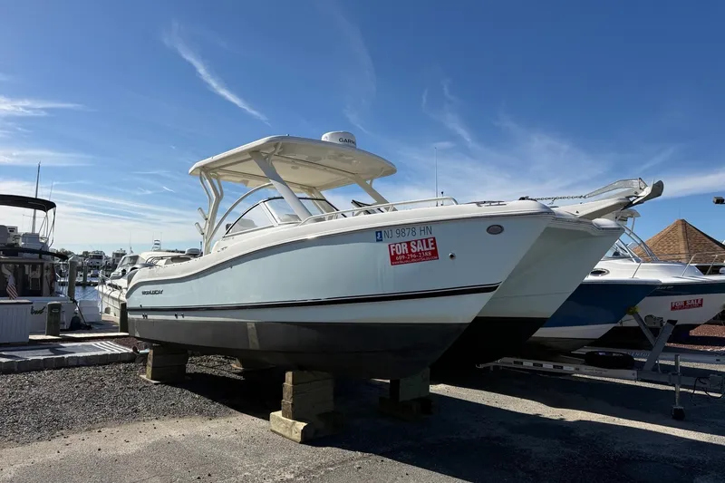 Slide: The Image of 2022 World Cat 255 DC boat for sale, docked on land under a clear blue sky. - 0