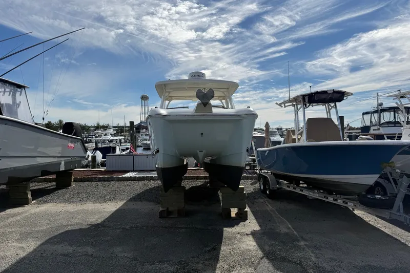 Slide: The Image of 2022 World Cat 255 DC boat on display at a marina under a blue sky. - 2