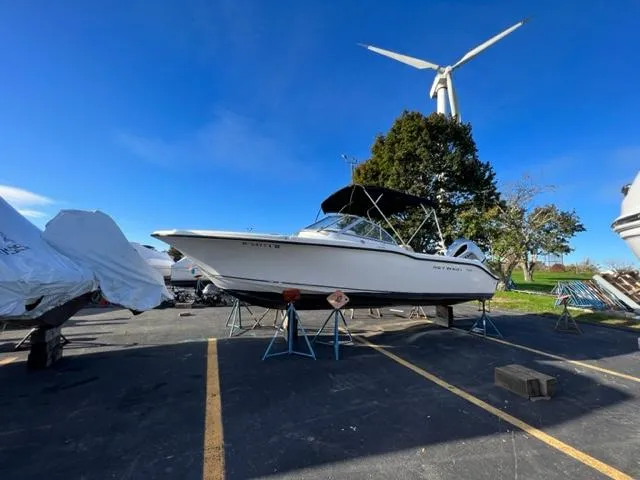Slide: The Image of 2020 Key West 239 DFS boat on stands in a parking lot with wind turbine. - 1