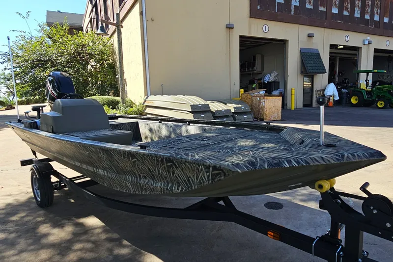 The Image of 2027 Tracker Grizzly 1648 SC boat on trailer, parked outside a building. - 0