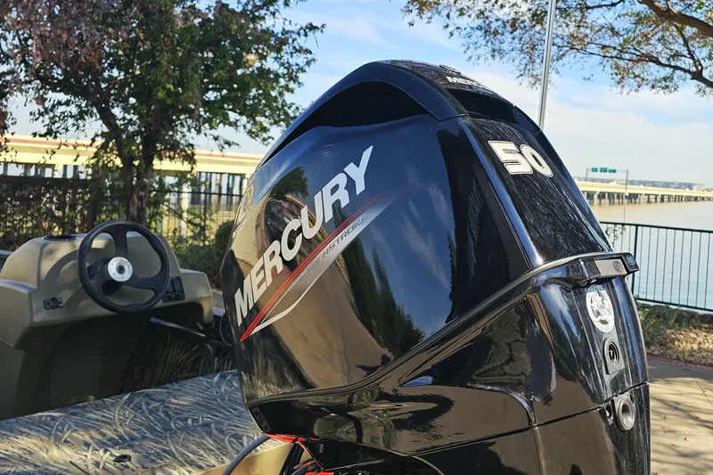 Slide: The Image of 2027 Tracker Grizzly 1648 SC boat with Mercury 50 outboard motor by a lakeside. - 14