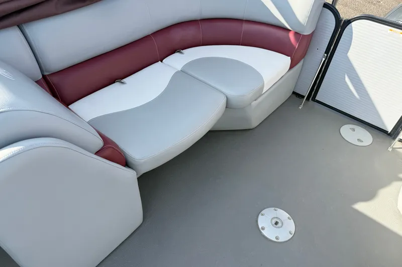 Slide: The Image of 2021 Manitou Aurora 21 boat interior with red and gray seating. - 7