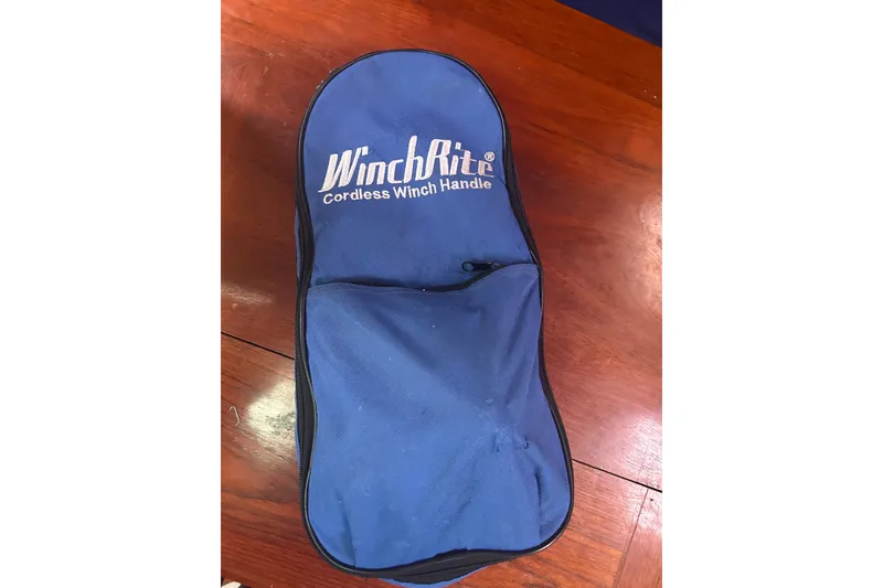 Slide: The Image of Blue WinchRite cordless winch handle bag on wooden surface, Catalina 34, 1988 model. - 47