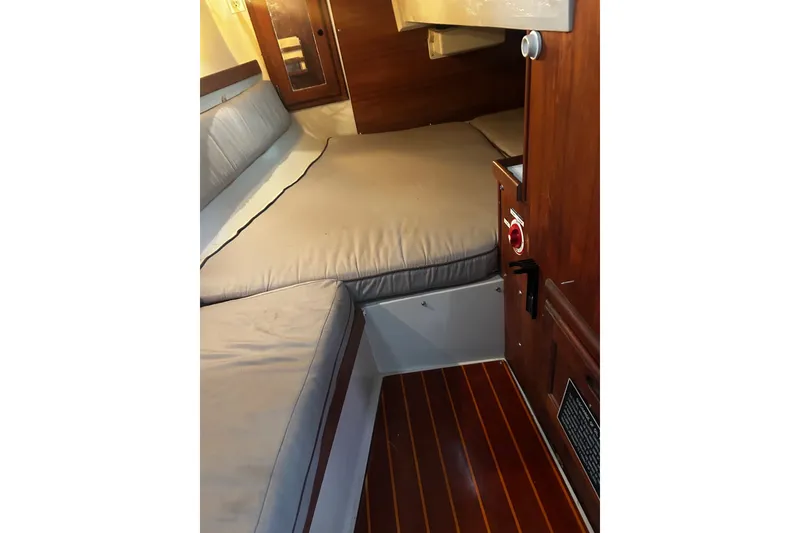 Slide: The Image of Interior cabin of a 1988 Catalina 34 sailboat with wooden flooring and cushioned seating. - 34