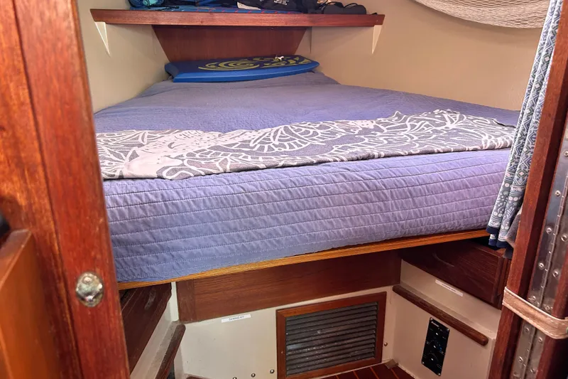 Slide: The Image of Cozy cabin interior of a 1988 Catalina 34 sailboat with a neatly made bed. - 30