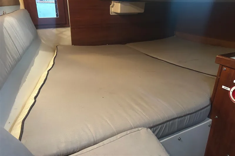 Slide: The Image of Interior of a 1988 Catalina 34 with cushioned sleeping area and wooden walls. - 36