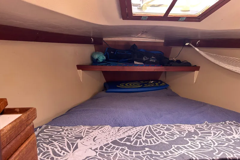 Slide: The Image of Cozy cabin interior of 1988 Catalina 34 sailboat with bedding and storage shelf. - 29