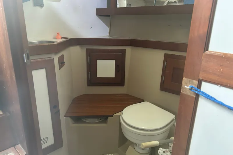 Slide: The Image of Interior of 1988 Catalina 34 sailboat bathroom with wooden accents and compact design. - 38