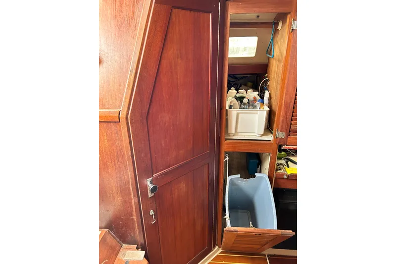 Slide: The Image of Interior of 1988 Catalina 34 sailboat with wooden cabinetry and storage compartments. - 42