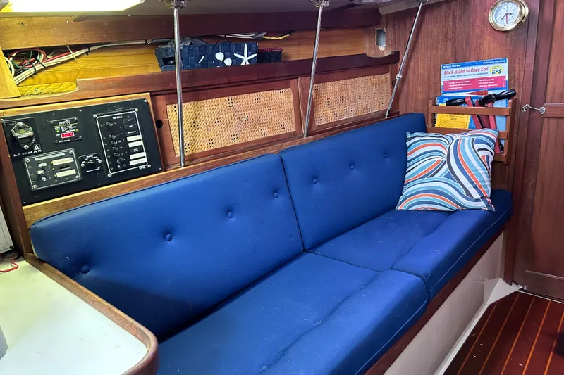 Slide: The Image of Interior of 1988 Catalina 34 sailboat with blue cushioned seating and nautical decor. - 14