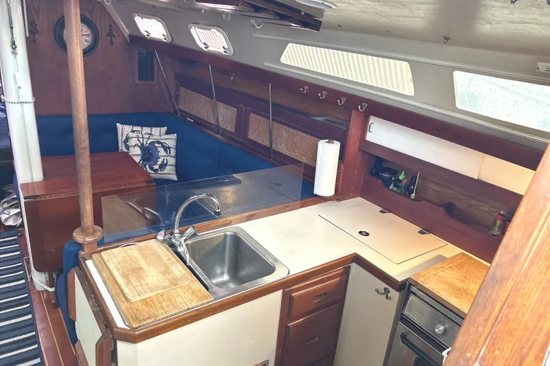 Slide: The Image of Interior of a 1988 Catalina 34 with a kitchen and seating area. - 23