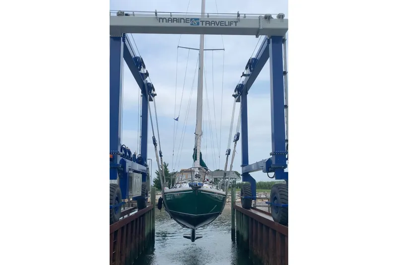 Slide: The Image of 1988 Catalina 34 sailboat being lifted by Marine Travelift at a dock. - 57