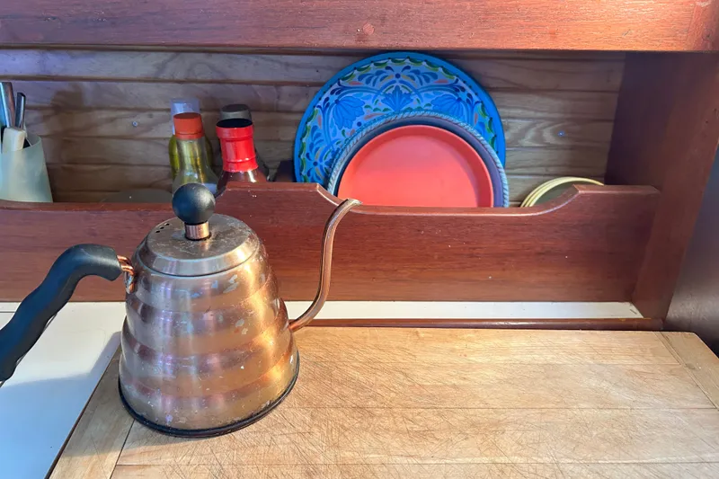 Slide: The Image of Copper kettle on wooden counter with colorful plates and condiments in a Catalina 34, 1988. - 26