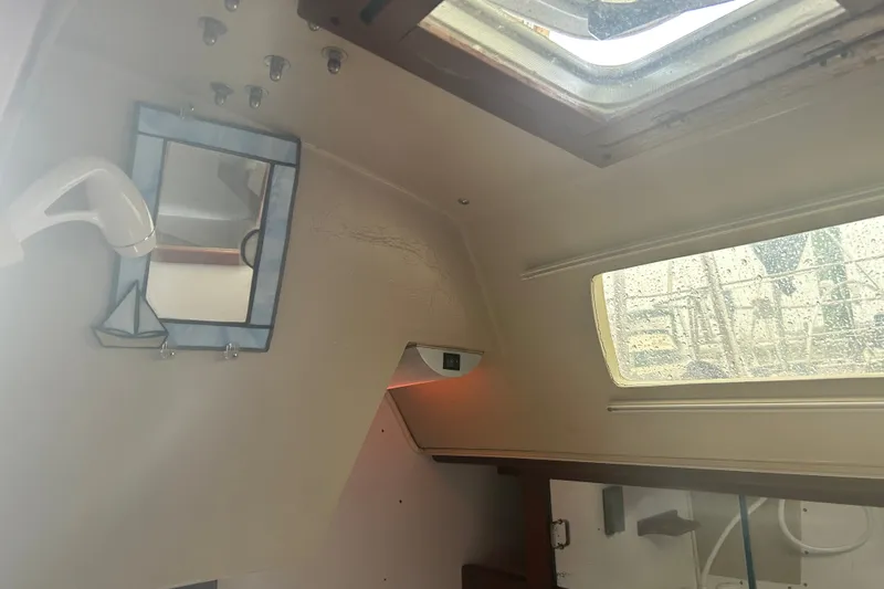 Slide: The Image of Interior of 1988 Catalina 34 sailboat with window, mirror, and showerhead. - 39
