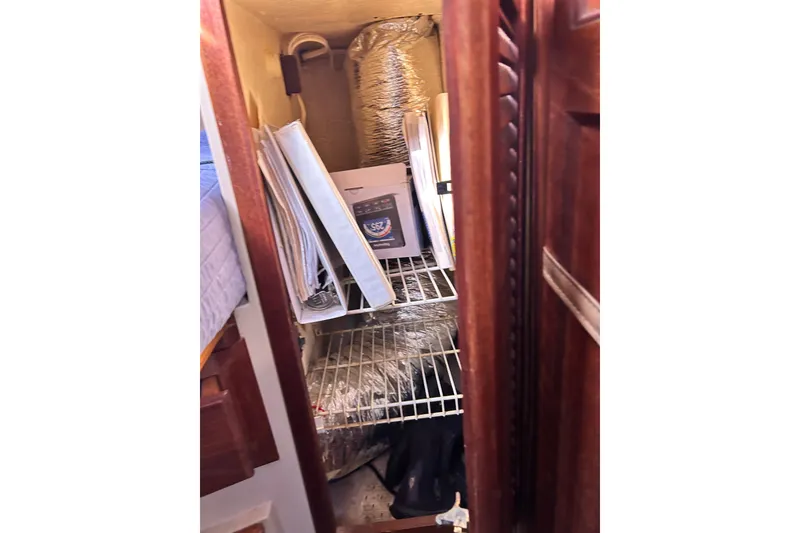 Slide: The Image of Storage compartment in a 1988 Catalina 34 sailboat with shelves and various items. - 33