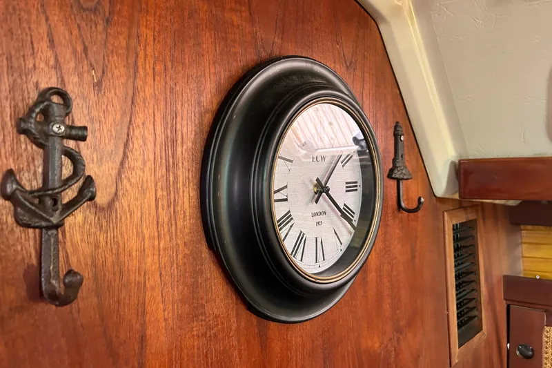 Slide: The Image of Wall-mounted clock and anchor hooks inside a 1988 Catalina 34 sailboat cabin. - 45