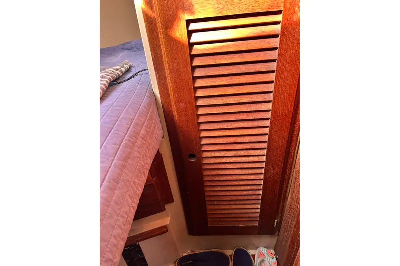Slide: The Image of Interior of 1988 Catalina 34 sailboat with wooden louvered door and bed. - 32