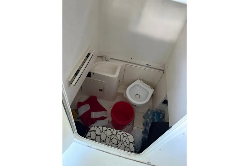 Slide: The Image of 2007 Robalo R300 Center Console boat interior with toilet and storage items. - 9