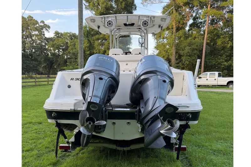Slide: The Image of 2007 Robalo R300 Center Console with twin outboard engines on a grassy area. - 3