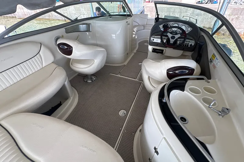 Slide: The Image of Interior of a 2005 Azure AZ240 boat with white seating and steering console. - 7