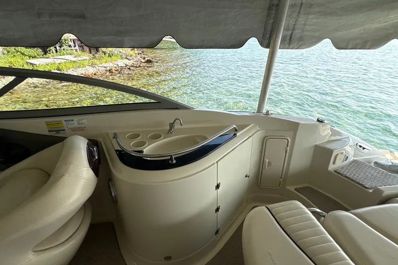 Slide: The Image of Interior of 2005 Azure AZ240 boat with seating and sink, overlooking clear water. - 8
