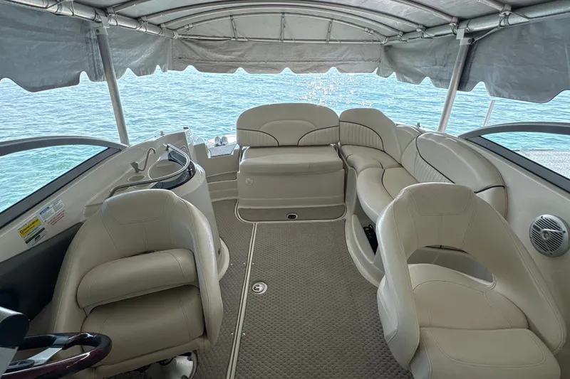 Slide: The Image of Interior of 2005 Azure AZ240 boat with beige seating and canopy over water. - 6