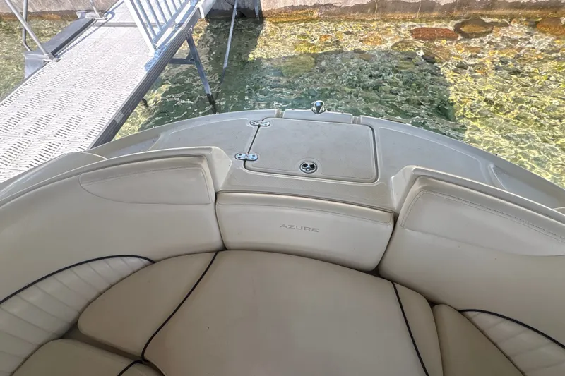 Slide: The Image of 2005 Azure AZ240 boat interior with beige seating near clear water and dock. - 17
