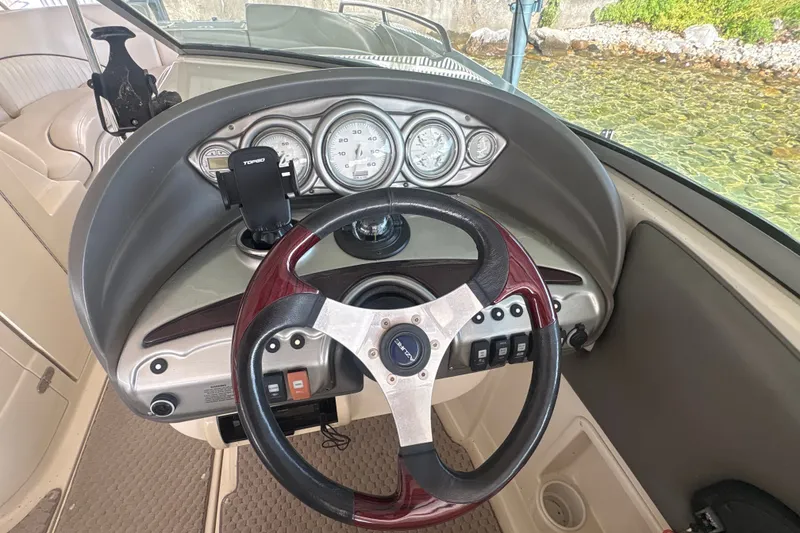 Slide: The Image of Steering wheel and dashboard of a 2005 Azure AZ240 boat, featuring gauges and controls. - 14