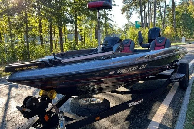 Slide: The Image of 2018 Triton 189 TrX boat on trailer in wooded area, sunny day. - 19