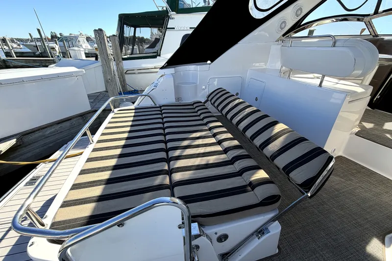 Slide: The Image of 2006 Regal Commodore 3760 IO boat with striped seating at a marina. - 4