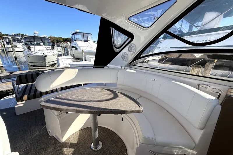 Slide: The Image of 2006 Regal Commodore 3760 IO yacht interior with white seating and table at marina. - 10