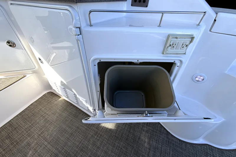 Slide: The Image of 2006 Regal Commodore 3760 IO boat interior with open storage compartment and trash bin. - 7