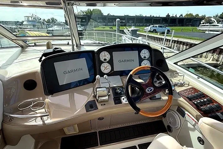 Slide: The Image of 2003 Sea Ray 500 Sundancer helm with Garmin displays and wooden steering wheel. - 8