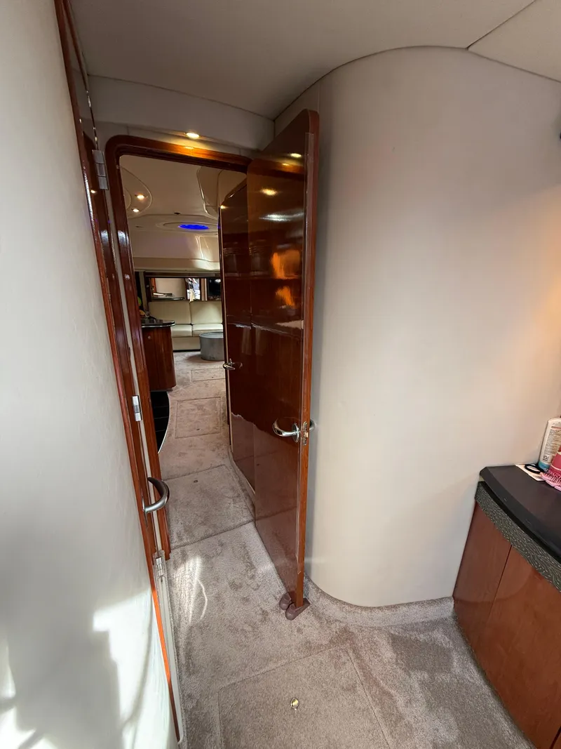 Slide: The Image of Interior hallway of 2003 Sea Ray 500 Sundancer yacht with wooden door and carpeted floor. - 23