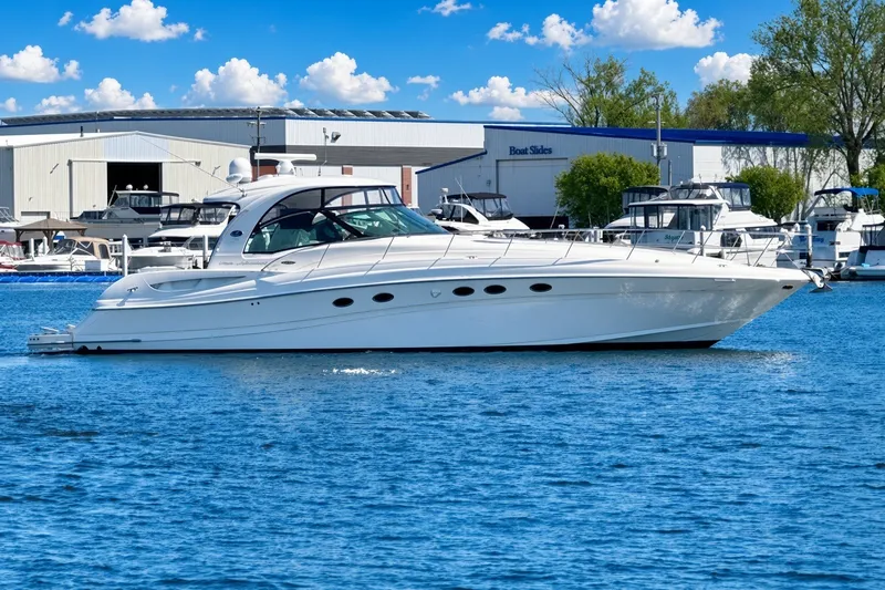 Slide: The Image of 2003 Sea Ray 500 Sundancer yacht docked in marina under blue sky. - 2