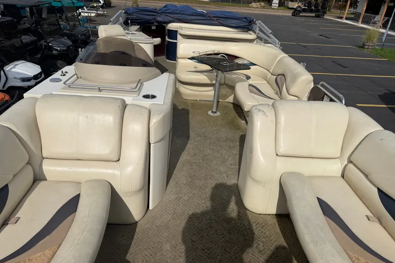 Slide: The Image of 2010 Sylvan 8525 Mandalay pontoon boat interior with beige seating and table. - 10