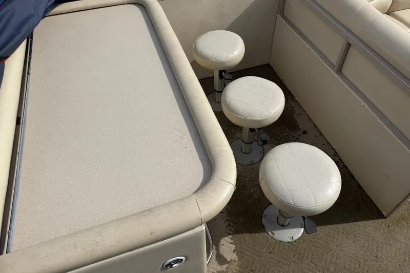 Slide: The Image of Interior of 2010 Sylvan 8525 Mandalay boat with white seating and table. - 15