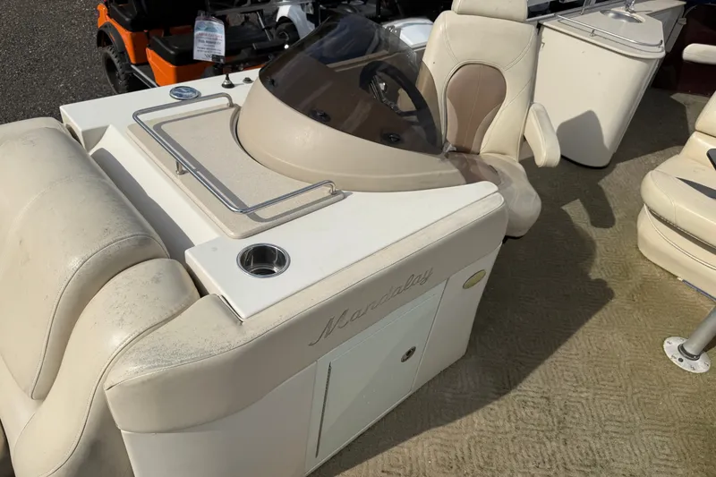 Slide: The Image of 2010 Sylvan 8525 Mandalay boat interior with beige seating and helm console. - 11