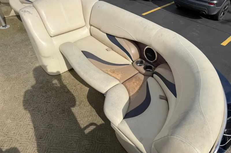 Slide: The Image of 2010 Sylvan 8525 Mandalay boat seating with cup holders, showing wear and tear. - 9