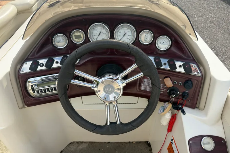 Slide: The Image of Steering wheel and dashboard of 2010 Sylvan 8525 Mandalay boat, featuring gauges and controls. - 3
