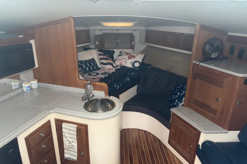 Slide: The Image of Interior of a 1995 Cabo 35 Express boat with cozy seating and kitchenette. - 12