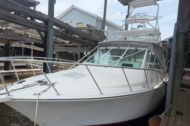 Slide: The Image of 1995 Cabo 35 Express boat docked at a marina, showcasing sleek design and sturdy build. - 1