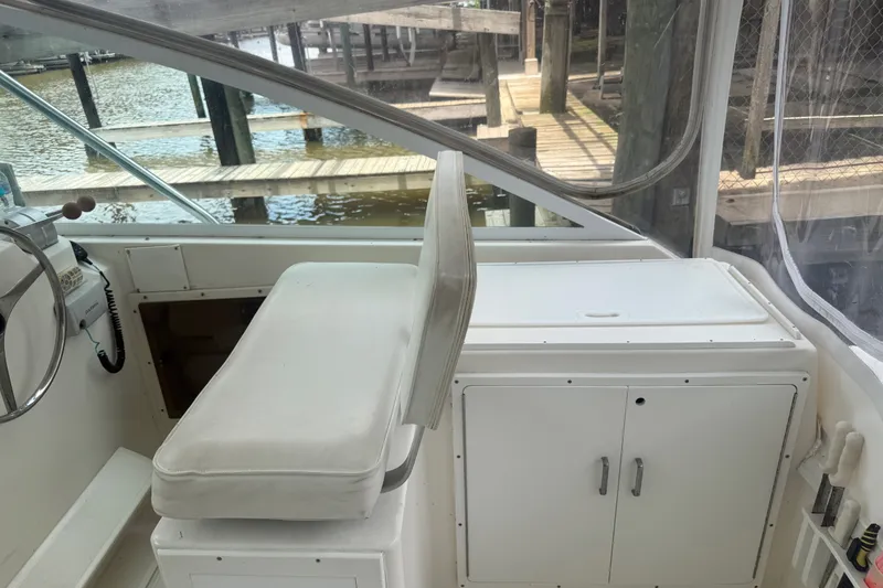 Slide: The Image of Interior of a 1995 Cabo 35 Express boat with helm seat and storage cabinet. - 15