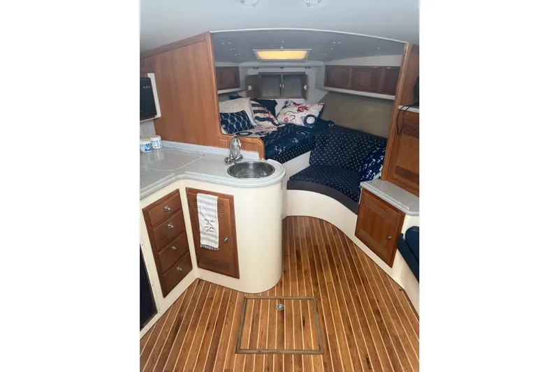 Slide: The Image of Interior of a 1995 Cabo 35 Express boat with wood flooring and cozy seating area. - 6