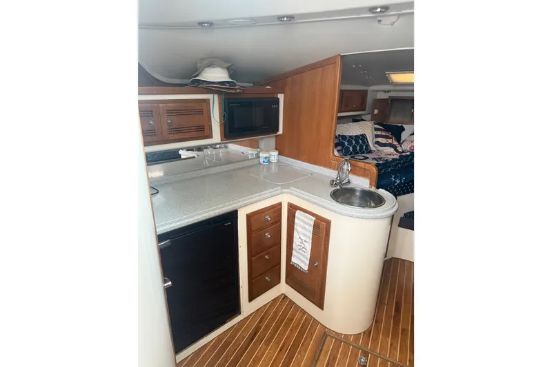 Slide: The Image of Interior of 1995 Cabo 35 Express yacht with kitchenette and cozy sleeping area. - 7